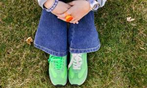 Arms and legs of girl sitting on grass